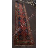 A Turkish wool runner with geometric pattern in predominantly red and blue 460cms long 100cms wide