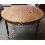 A circa 1950's G Plan Fresco, circular extending teak dining table on four tapering cylindrical