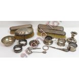 A collection of four silver napkin rings; a silver mustard pot; a silver rim from a bottle; four