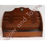 An Edwardian oak stationery rack fitted with a penslide to the front, 21.5cms high 32cms wide