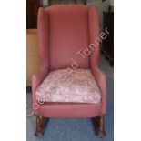 A late 19th Century/early 20th Century upholstered wing back chair of Arts and Crafts style and with