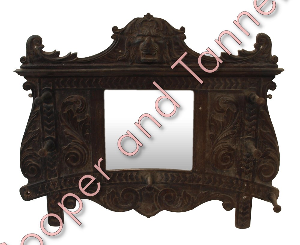 A Victorian carved oak hall mirror with lion mask pediment, central mirror in carved foliate