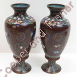 A pair of Japanese cloisonné pedestal vases decorated with chrysanthemum heads within mon and within