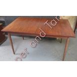 A circa 1950's extending rectangular teak dining table on four tapering cylindrical supports