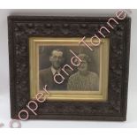 A late 19th/early 20th Century carved wood frame containing a photographic portrait