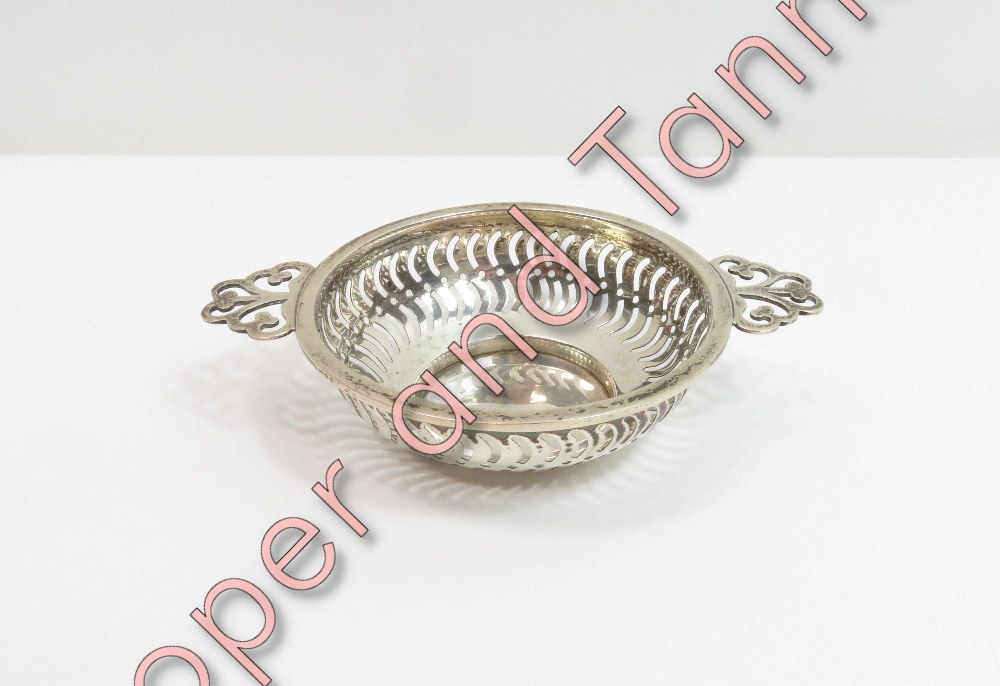 A silver two handled bon bon dish, by Synyer & Beddoes, Birmingham 1914, of circular outline with