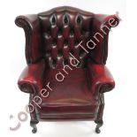 A modern red leather upholstered club style wing back chair by Winchester Furniture, having button