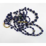 A collection of polished and facetted sapphire and other bead necklaces with white Tibetan metal