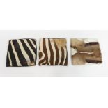 Two zebra skin cushion covers and an antelope skin cushion cover