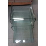 A nest of three heavy glass Italian made tables of curved form, largest 45.5cms high
