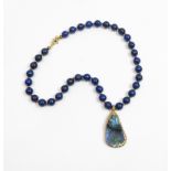 A necklace of uniform lapis lazuli beads with an iridescent mineral pendant attached, 44 cm