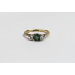 A diamond and emerald three stone ring, stamped '18ctPlat', the square cut emerald flanked either