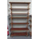 Three sets of free standing wood shelves each with shelves supported on shaped cylindrical supports,