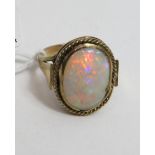 An unmarked gold ring set with an oval opal