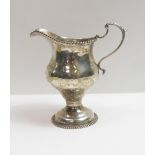 A Georgian silver cream jug, makers mark worn, London 1771, of baluster shape on a short pedestal