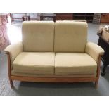 An Ercol two seater settee with lightwood frame and buttoned back cushions