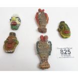 A group of five Phoenician glass amulets, two in the form of fish and three as heads