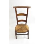 A Belgian rustic prie dieu chair with high back and low rush seat