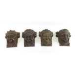 A group of eight carved oak bosses in the form of characterful masks, all of smiling faces, 28cms