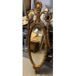 GILT FRAMED OVAL MIRROR WITH DECORATIVE CARVINGS