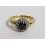 A round cut sapphire and diamond cluster ring, stamped '18ct', finger size I, 3.8 g gross