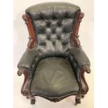 A Victorian mahogany open armchair, upholstered in black leather and with heavily carved