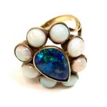 An opal cluster ring, stamped '9ct', the central opal doublet enclosed by eight round opals,