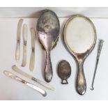 A silver purse vanity mirror, with hinged cover; a silver hand mirror; a silver hair brush; a silver