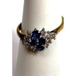 An 18 carat gold sapphire and diamond cluster ring, the four round cuts flanked either side by