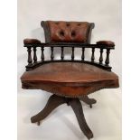 A 20th century mahogany captains chair, upholstered in dark orange leather, on four outswept legs on