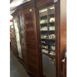 A large walnut wardrobe, with two mirrored sections, four long drawers and two door cupboard