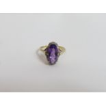 An amethyst and diamond 18 carat gold cluster ring, Birmingham 1975, the long oval cut stone