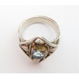 An Arts and Crafts stone set ring, the pale blue stone in a gold rubbed over setting, with leaf