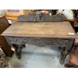 A Victorian oak carved hall table, with single drawer, heavily decorated to the front, 105cm long,