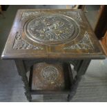 An oak side table, carved central motif and four corner motifs, 65cm high, 45cm long, 45cm