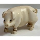 An Japanese ivory netsuke of a pig, with signature to the base, 5.3cm long