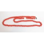 A row of round coral coloured glass beads