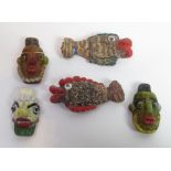 A group of five Phoenician glass amulets, two in the form of fish and three as heads