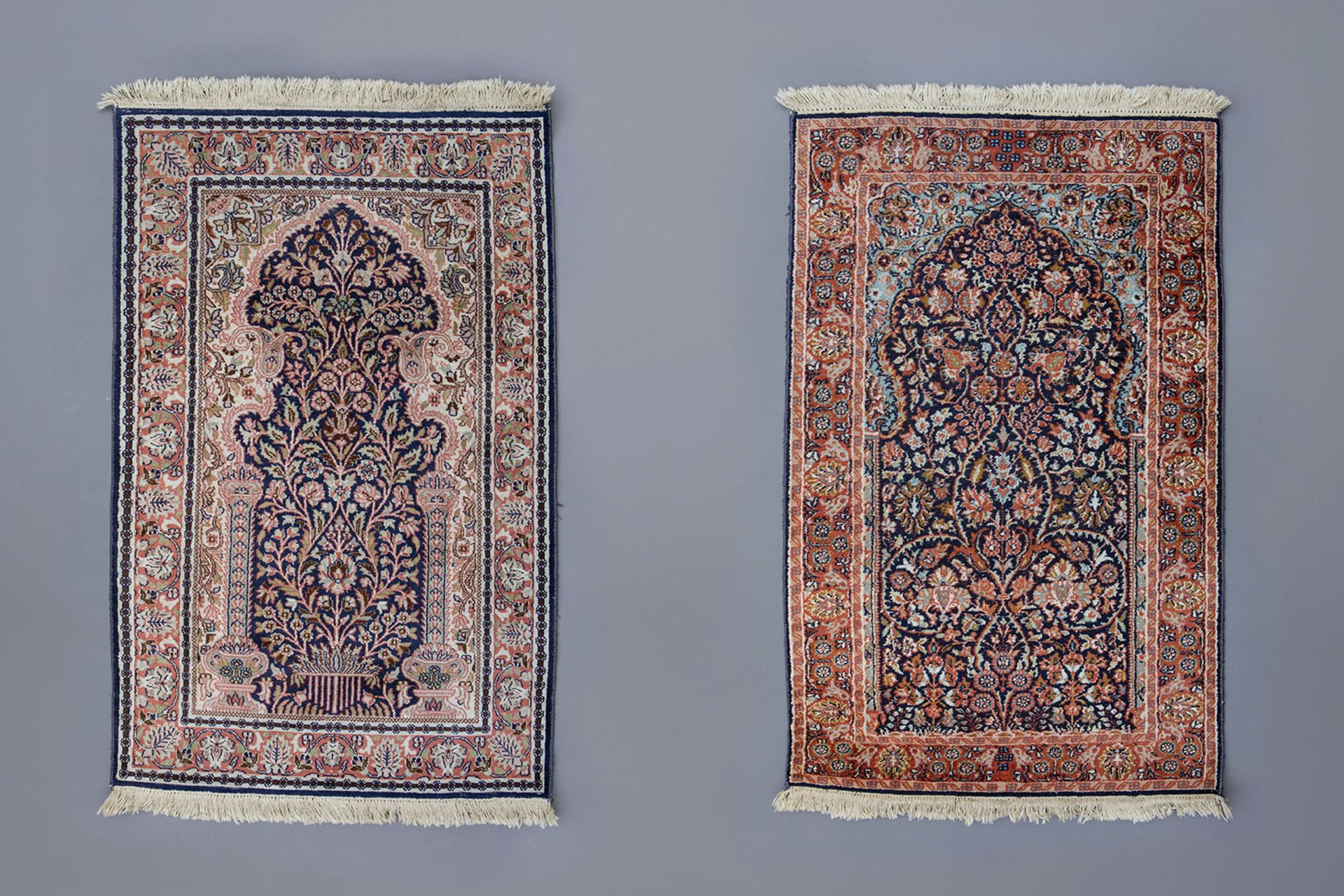 Two Oriental prayer rugs with floral design, silk on cotton, 20th C.