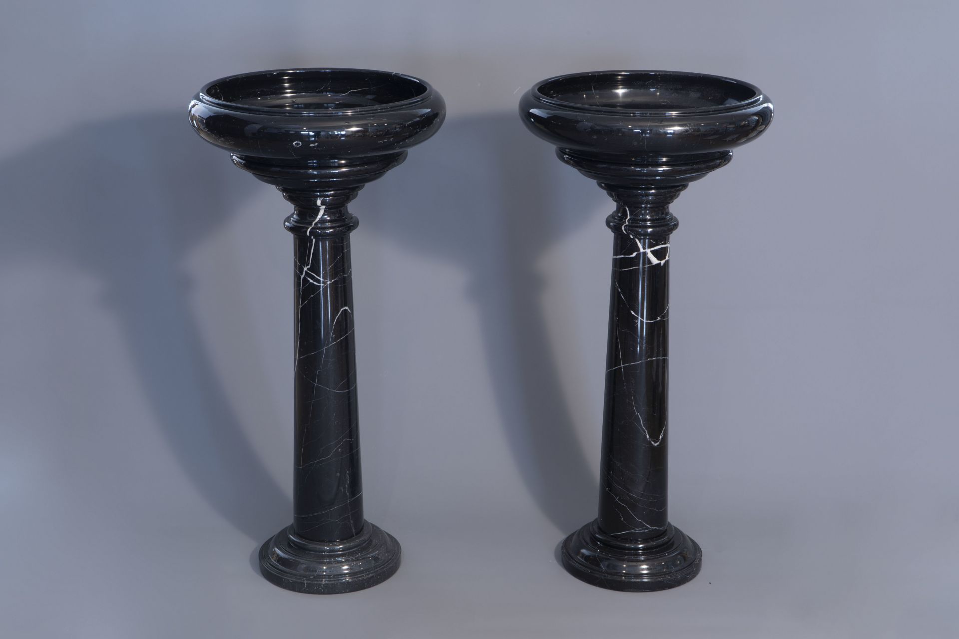 A pair of black-gray marble pedestals with a bowl, 20th C.