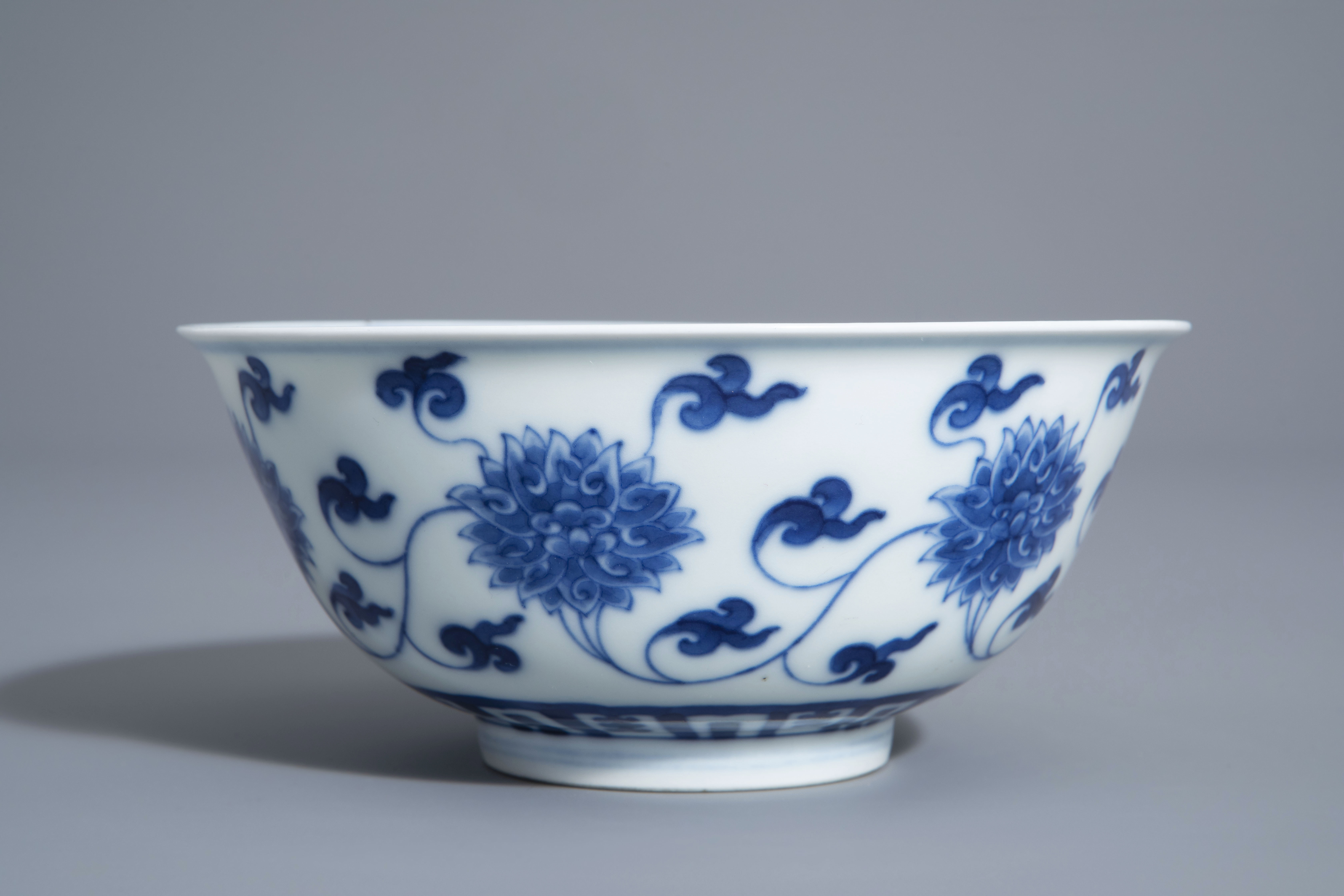 A Chinese blue and white 'lotus scroll' bowl, Kangxi mark, 19th/20th C. - Image 5 of 8