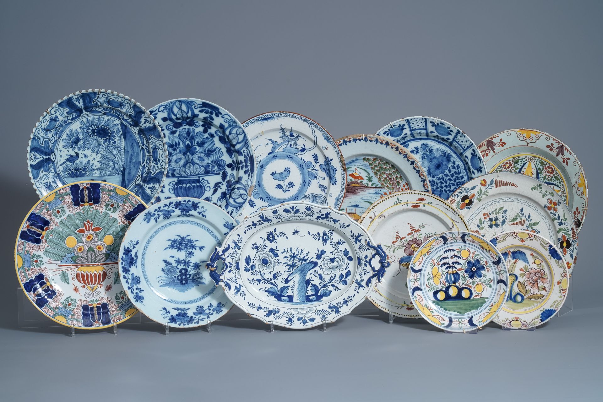 Twelve polychrome and blue and white Dutch Delft plates and an oval tray, 18th C.