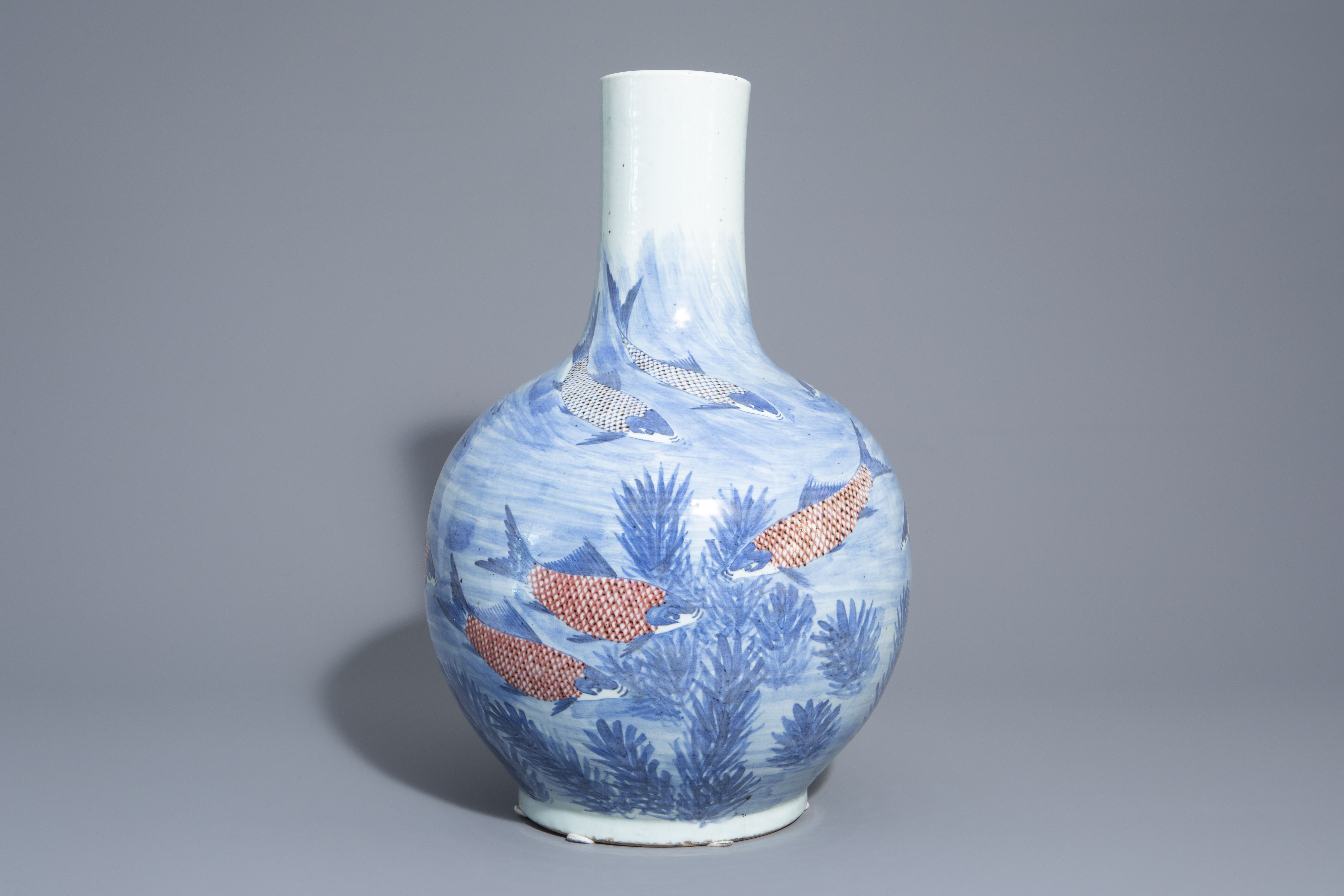 A large Chinese blue, white and copper red bottle shaped 'carps' vase, 20th C.
