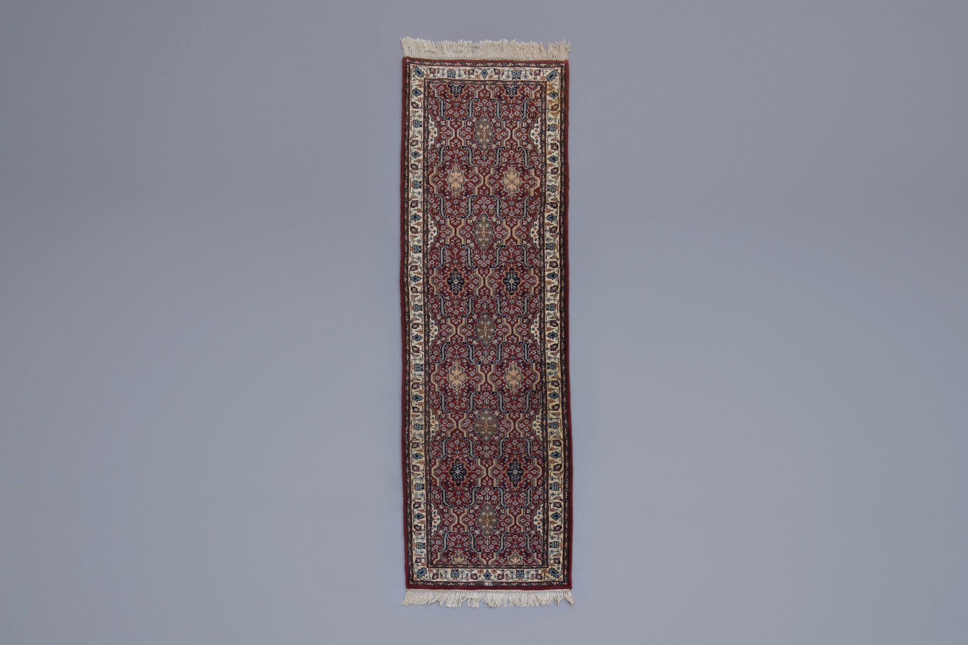 An Oriental runner with floral design, wool on cotton, 20th C.