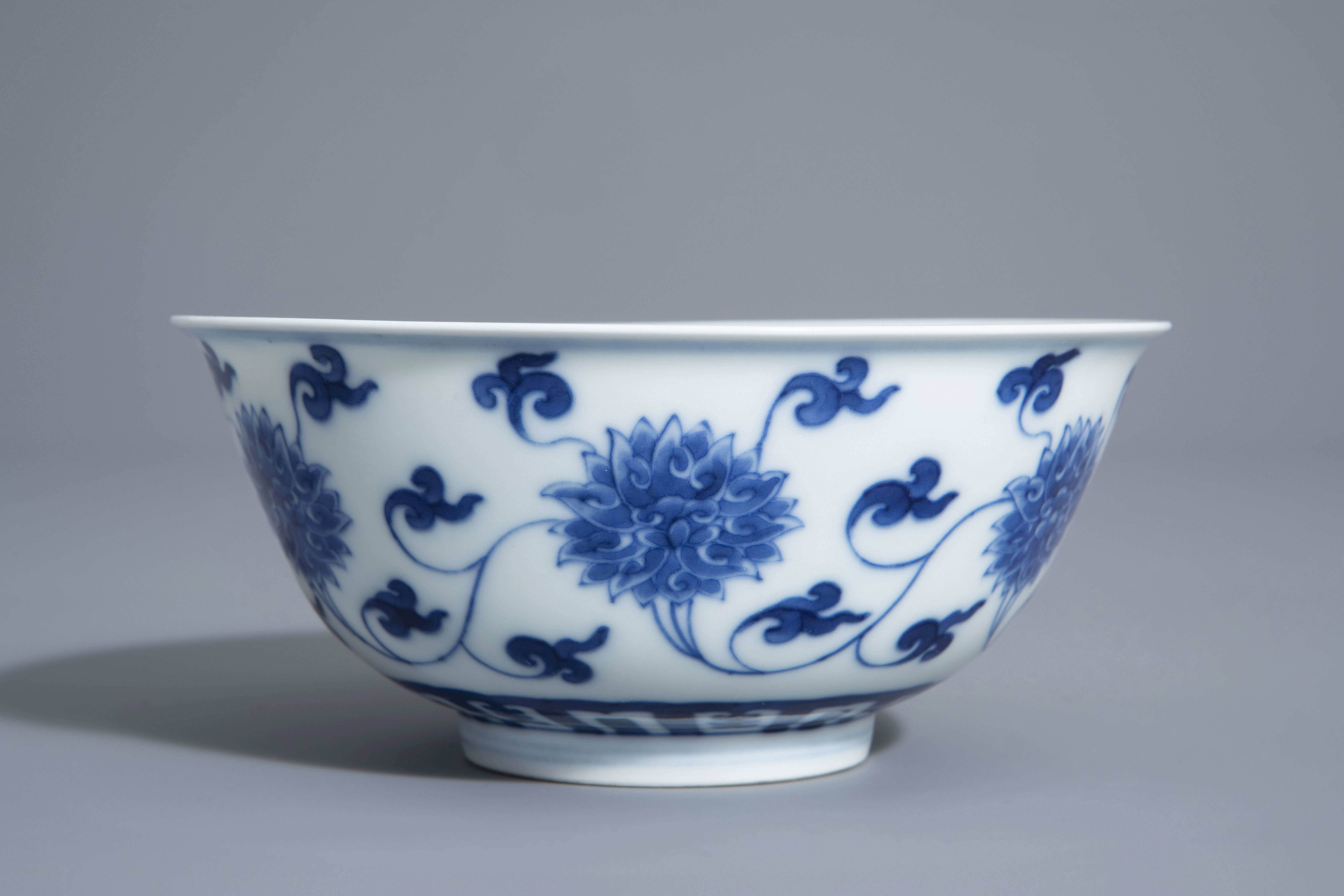 A Chinese blue and white 'lotus scroll' bowl, Kangxi mark, 19th/20th C. - Image 2 of 8