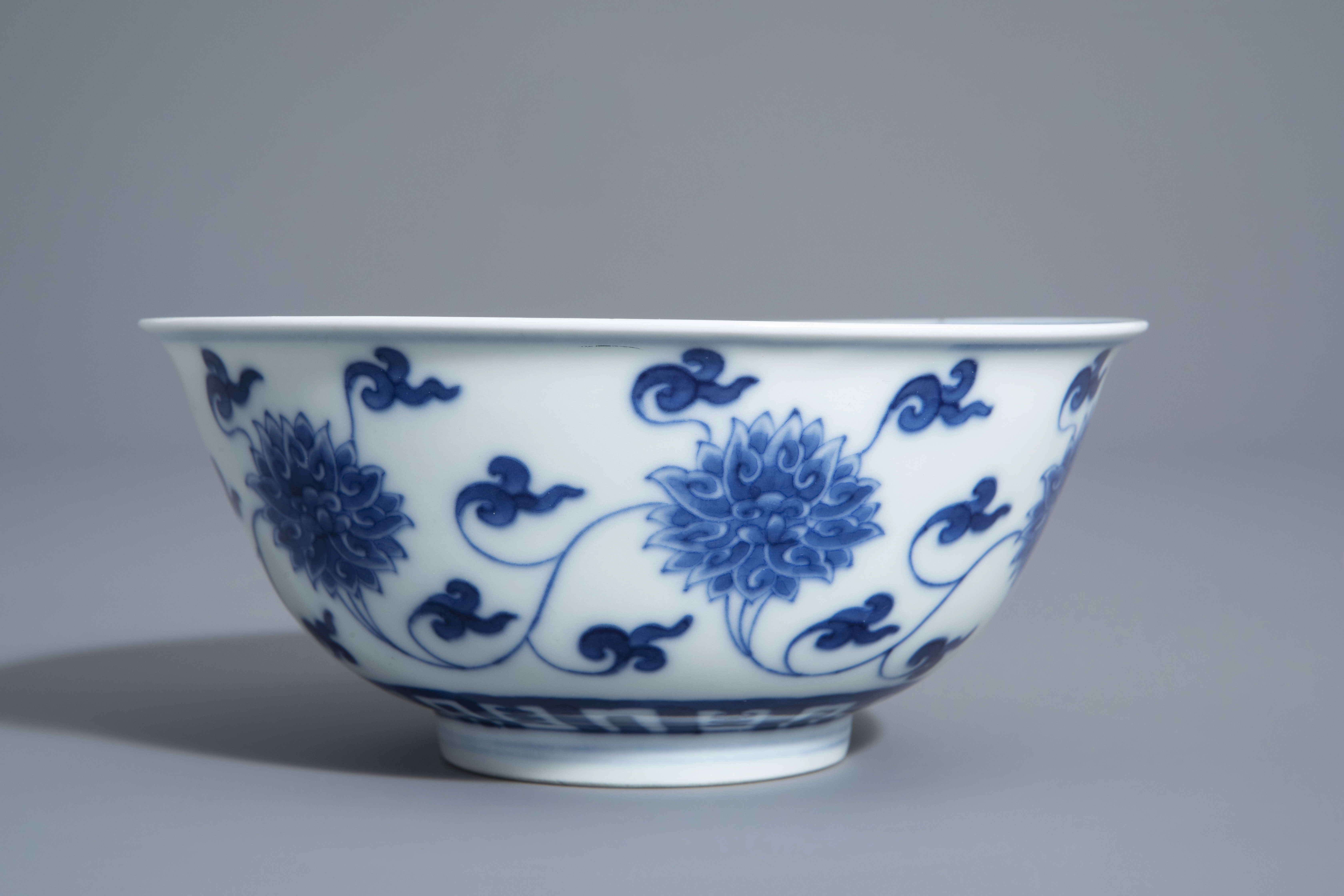 A Chinese blue and white 'lotus scroll' bowl, Kangxi mark, 19th/20th C. - Image 4 of 8