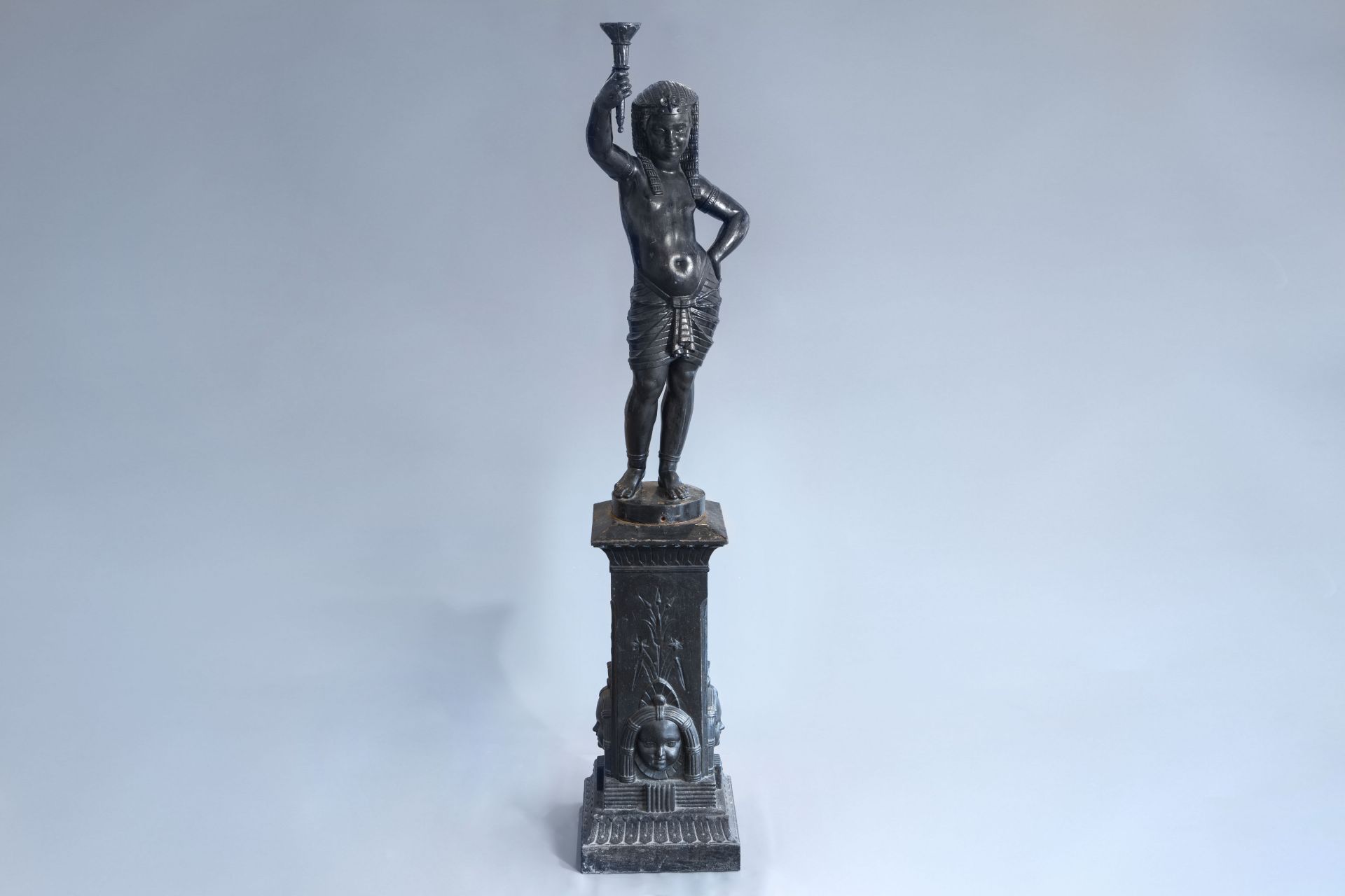 A cast iron figure on a pedestal of an Egyptian with torch, style of Val d'osne, France, about 1900