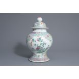 A Chinese famille rose vase and cover with floral design, 19th C.