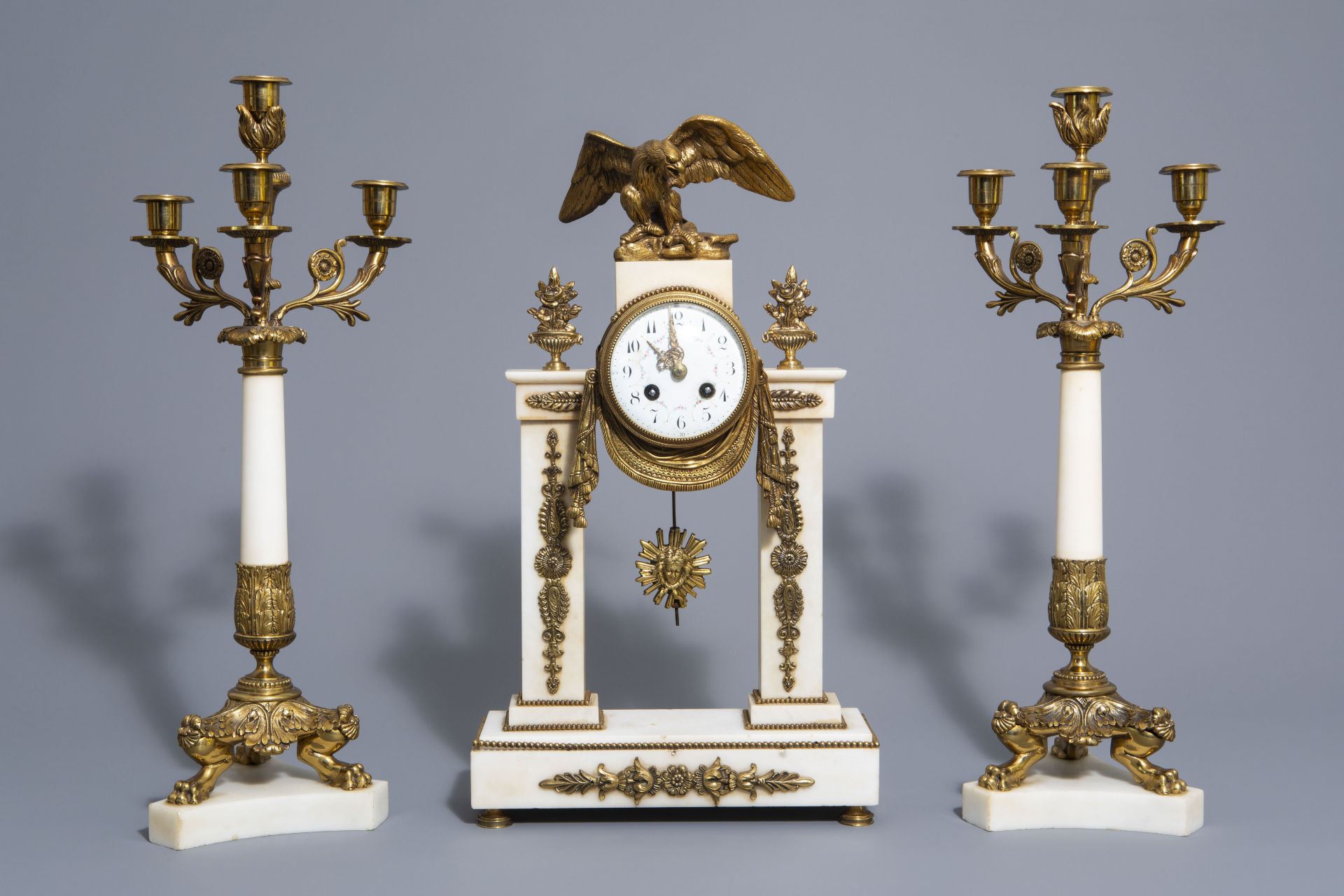 A three-piece gilt mounted and white marble garniture with an eagle, France, 19th/20th C.