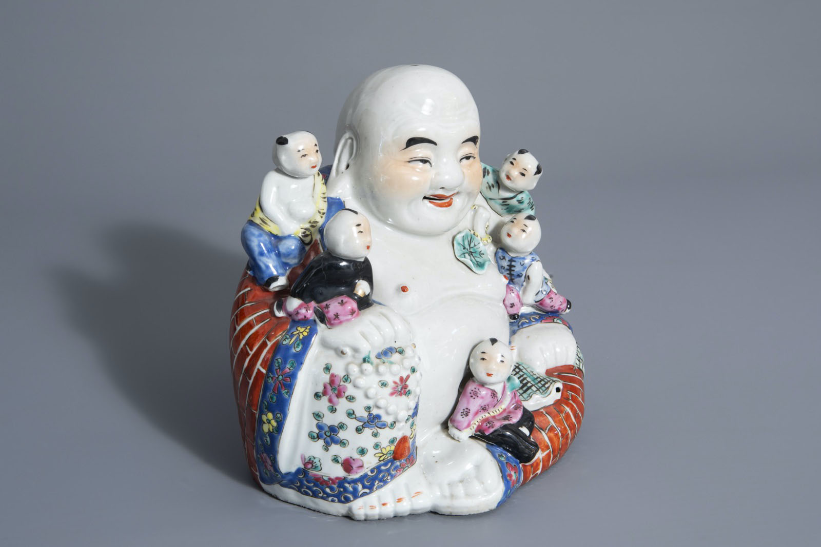 A Chinese famille rose figure of Buddha with children, 19th/20th C.